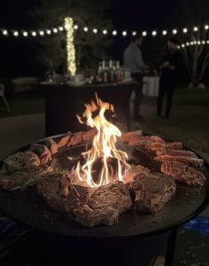Viande grillée sur un brasero avec des lumières en arrière-plan