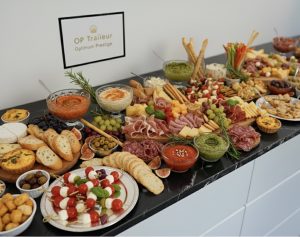 Buffet varié avec charcuterie, fromages, et dips sur une table.