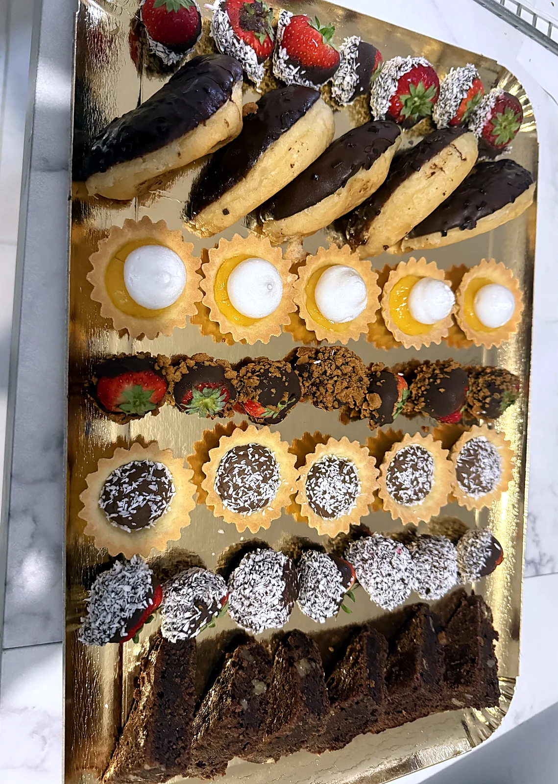 Plateau de mignardises : éclairs, tartelettes et fraises au chocolat pour baptême